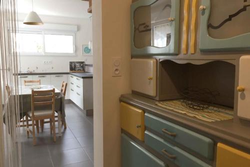 une cuisine et une salle à manger avec une table. dans l'établissement Au grès des pins, à Erquy