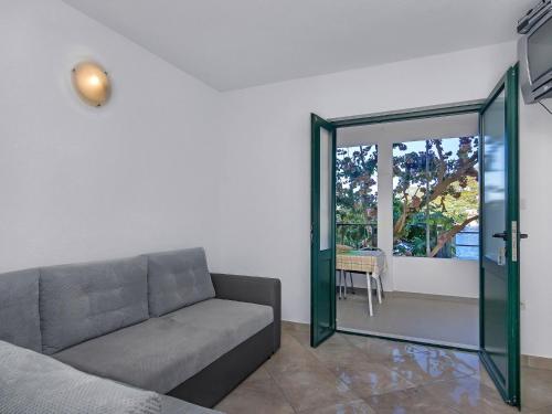 a living room with a couch and a sliding glass door at Apartment Rubin-2 by Interhome in Zastražišće
