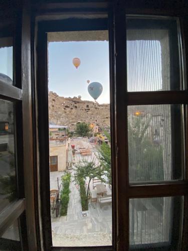ein Fenster mit Blick auf Heißluftballons in der Unterkunft Cappadocia Fairy Tale Suites in Goreme