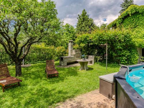a backyard with a pool and two chairs and a fountain at Holiday Home La Rina by Interhome in Dervio