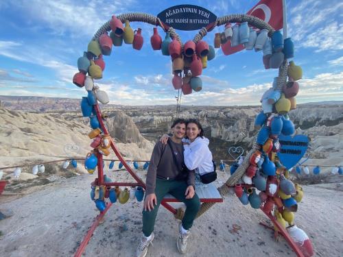 un homme et une femme assis sur une balançoire au grand canyon dans l'établissement Cappadocia Fairy Tale Suites, à Gorëme