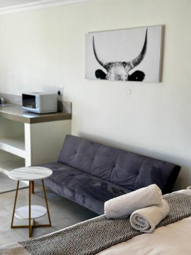 a living room with a couch and a picture of a cow at Rosetta Fields Country Lodge in Rosetta