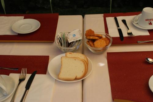 a table with a plate of bread and some snacks at Hotel Cristallo in Venice-Lido