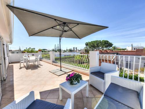 a patio with an umbrella and chairs and a table at Apartment MareLuna by Interhome in Fontane Bianche