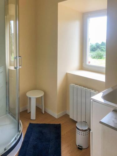 La petite salle de bains est pourvue d'une douche et d'une fenêtre. dans l'établissement BOILLOT, Trebeurden in a quiet area with sea view, à Trébeurden