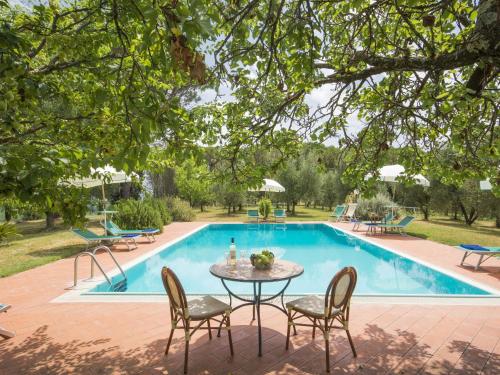 una mesa y sillas frente a una piscina en Holiday Home Il Leccio by Interhome, en Vitolini