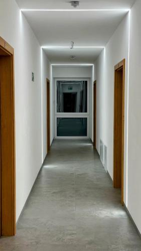 an empty hallway with white walls and a window at Bursztynowa Rosa & Wypożyczalnia rowerów elektrycznych in Łeba