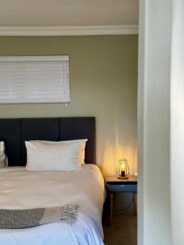 a bedroom with a bed and a table with a lamp at Rosetta Fields Country Lodge in Rosetta