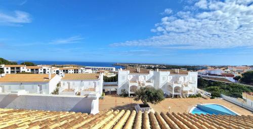 Vista árida de una ciudad con edificios blancos y el océano en Apartamento 314 Castell Sol en Arenal d'en Castell