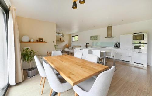 une cuisine et une salle à manger avec une table et des chaises en bois dans l'établissement Stunning Home In St Laurent Des Arbres, à Saint-Laurent-des-Arbres