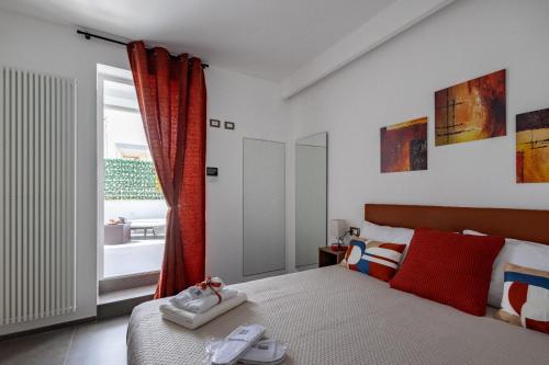a bedroom with a bed with red curtains and a window at Le Suite di Magda Relax & Rooms in Polignano a Mare