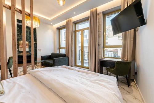 sypialnia z łóżkiem, biurkiem i telewizorem w obiekcie Royal Gold City Suites by Estia w Heraklionie