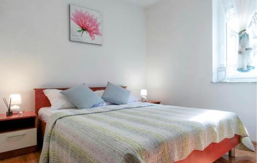 una camera da letto con un letto con un fiore rosa sul muro di Cozy Apartment In Smrika With Kitchen a Šmrika