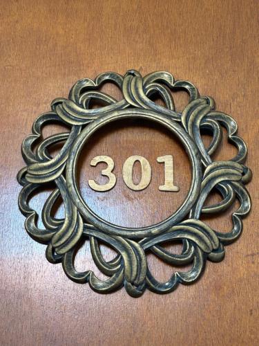 a metal sign with the number on a wall at Dionisos Roses in Paralia Dionysiou