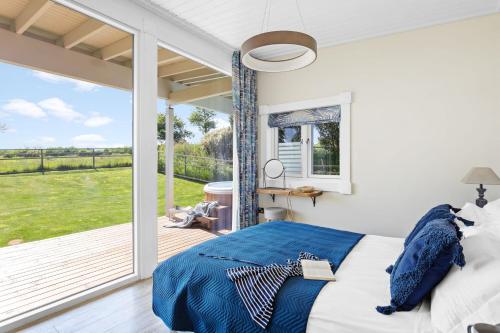 Un dormitorio con una cama y una ventana grande. en Rafters Lodge, Nr Saunton, en Georgeham