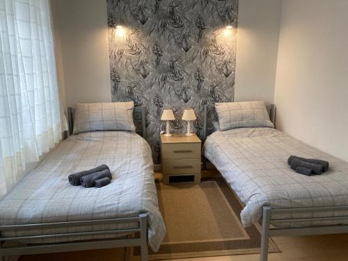 two twin beds in a room with a wall at Cheerful two bedroom house PLONEVEZ du Faou in Plonévez-du-Faou