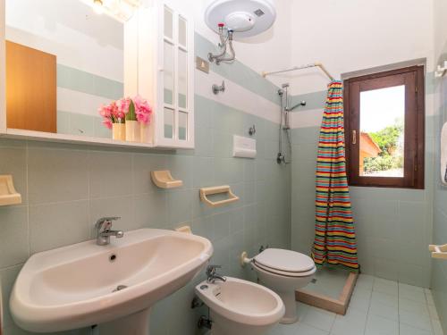 a bathroom with a sink and a toilet and a window at Holiday Home Mare-3 by Interhome in Li Valcaggi