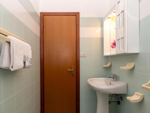 a bathroom with a sink and a wooden door at Holiday Home Mare-3 by Interhome in Li Valcaggi