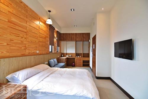 a bedroom with a bed and a flat screen tv at Captain Ou Homestay in Huxi