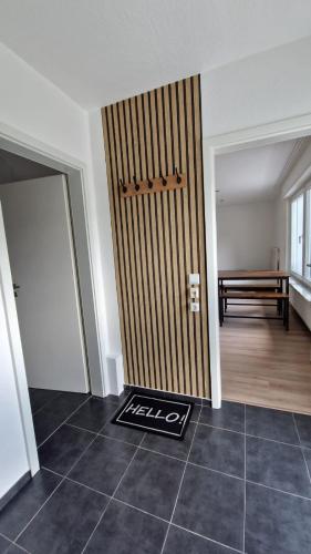 a room with a door with a bench in the background at MaxMir - Tannenweg Iserlohn, zentral - Parken - Küche - Netflix - Prime in Iserlohn
