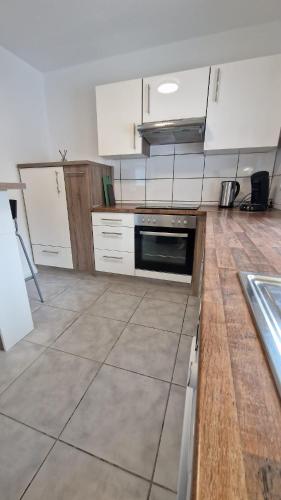 a kitchen with white cabinets and a stove top oven at MaxMir - Tannenweg Iserlohn, zentral - Parken - Küche - Netflix - Prime in Iserlohn