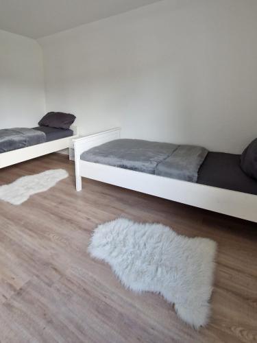 a bedroom with two beds and a white rug at MaxMir - Tannenweg Iserlohn, zentral - Parken - Küche - Netflix - Prime in Iserlohn