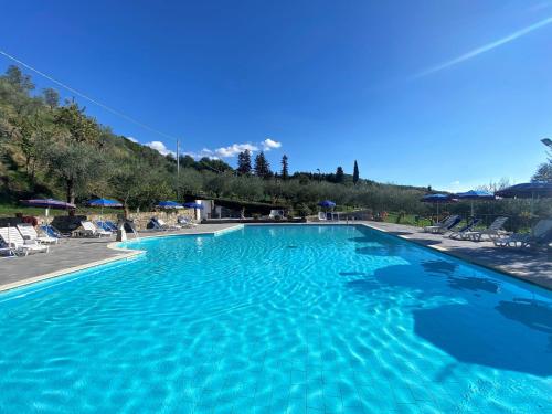 een groot zwembad met blauw water bij Apartment Villa Grassina-9 by Interhome in Pelago