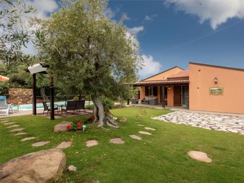 a yard with a tree and a house at Villa Olivella by Interhome in Lascari