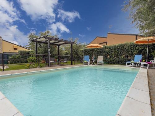 a large swimming pool with umbrellas and chairs at Villa Olivella by Interhome in Lascari