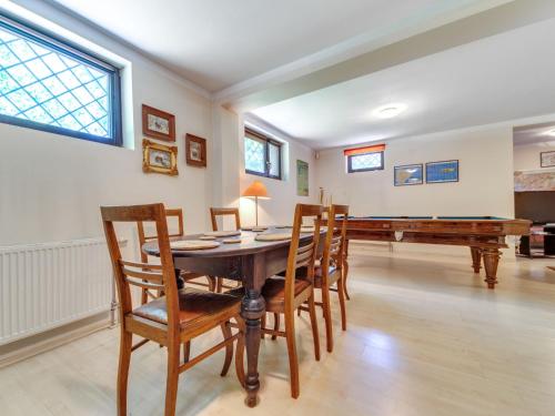 a dining room with a table and a piano at Apartment Marcyporęba by Interhome in Marcyporęba