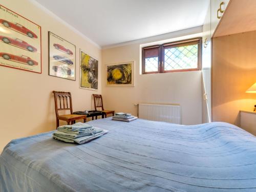 a bedroom with a large bed with a blue blanket at Apartment Marcyporęba by Interhome in Marcyporęba