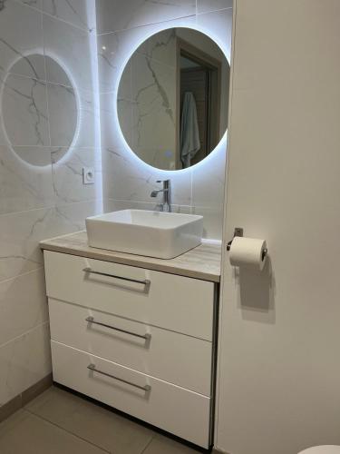 une salle de bain avec un lavabo et un miroir dans l'établissement Joli 3 pièces ensoleillé sur les hauteurs de Nice, à Nice