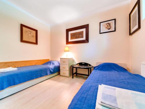 a bedroom with two beds and a table at Apartment Marcyporęba by Interhome in Marcyporęba
