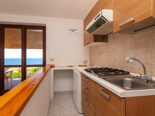 a kitchen with a sink and a stove at Holiday Home Mare-2 by Interhome in Li Valcaggi