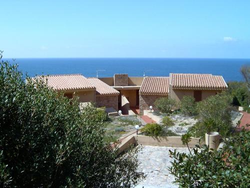 a view of two houses with the ocean in the background at Holiday Home Mare-2 by Interhome in Li Valcaggi