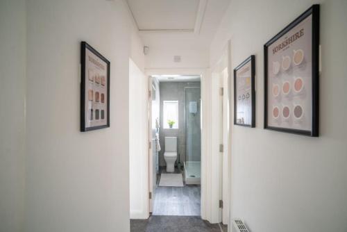 a hallway with three framed pictures on the walls at The Station Inn Apartment in Yeadon
