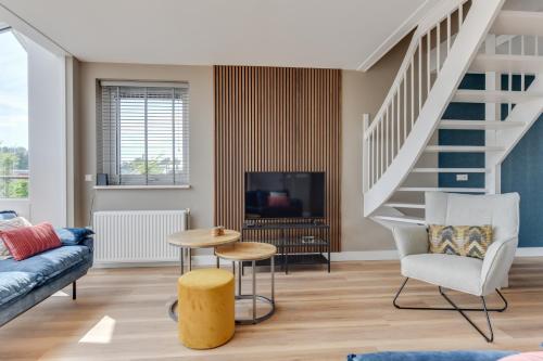 a living room with a couch and a tv at Meerzicht 57 - 3 bedroom appt with sunny terrace in Uitgeest