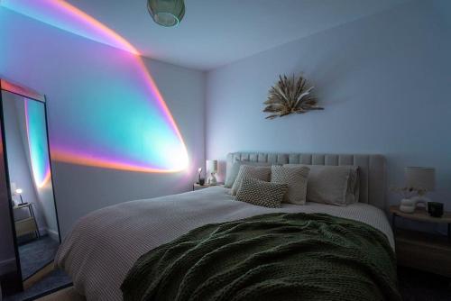 a room with a bed with a rainbow on the wall at The Station Inn Apartment in Yeadon
