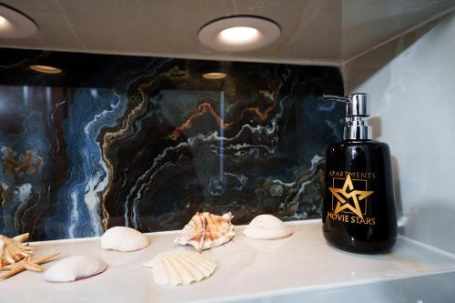 a bottle of soap and some shells on a counter at LUX Movie Stars Apartments Perea in Perea