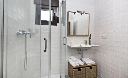 Un baño con ducha, lavabo y espejo. en Senda del Cabrerizo, en Albarracín