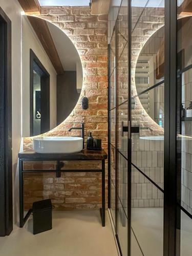 a bathroom with a sink and a brick wall at Loft 16 - Luksus & Relax - Wanna, Netflix, Parking in Iława