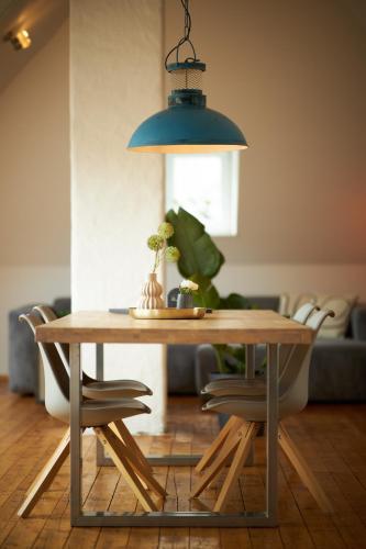 a dining room table with a blue lamp and chairs at Mosel-Loft in Bernkastel-Kues
