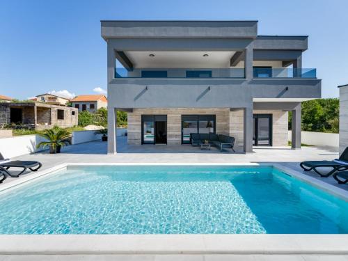 a house with a swimming pool in front of a house at Villa Solis by Interhome in Maslenica