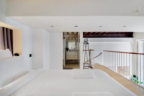 a bedroom with a white bed and a balcony at GemBnB Luxury Apartments - Temple in Paris
