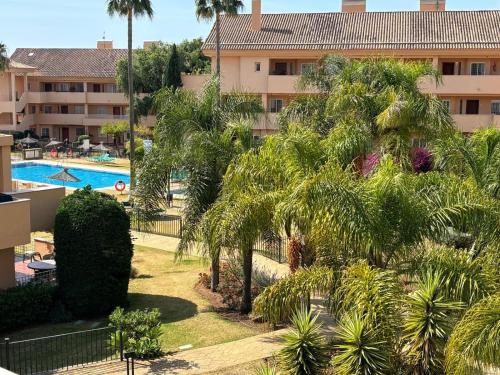 a view of a resort with a pool and palm trees at Luxury Duplex Penthouse in Marbella