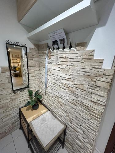 a stone wall in a room with a table and a mirror at MILET style and spacy 2 room apartment with AC in Bratislava Nivy in Nivy