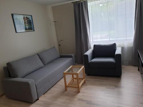 a living room with a couch and a chair at Crow's nest in Grobiņa