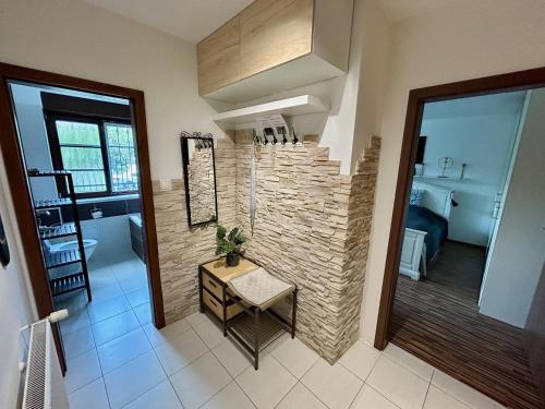 a room with a stone wall and a table and a bathroom at MILET style and spacy 2 room apartment with AC in Bratislava Nivy in Nivy
