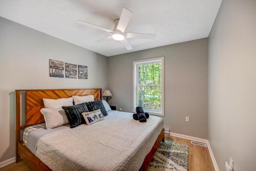a bedroom with a bed with a ceiling fan at 1 Mi to Beach Pocono Lake Chalet with Decks in Pocono Lake