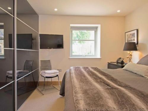 a bedroom with a bed and a desk and a tv at Discovery - Luxury Cosy Country Escape in Grantham